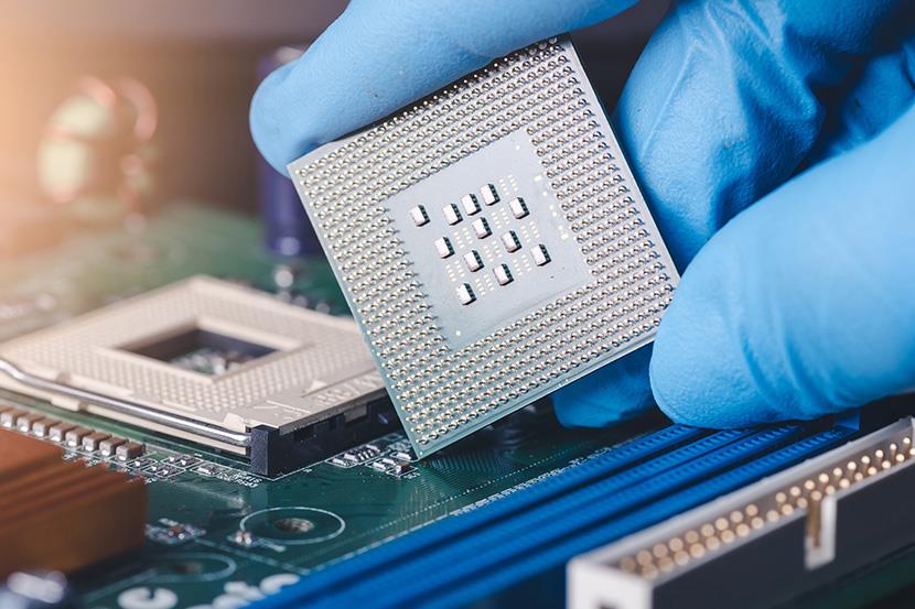 technician laying a cpu on the socket of a computer motherboard