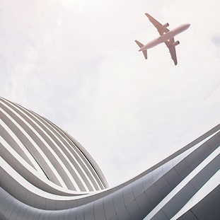 view of airplane flying over modern building